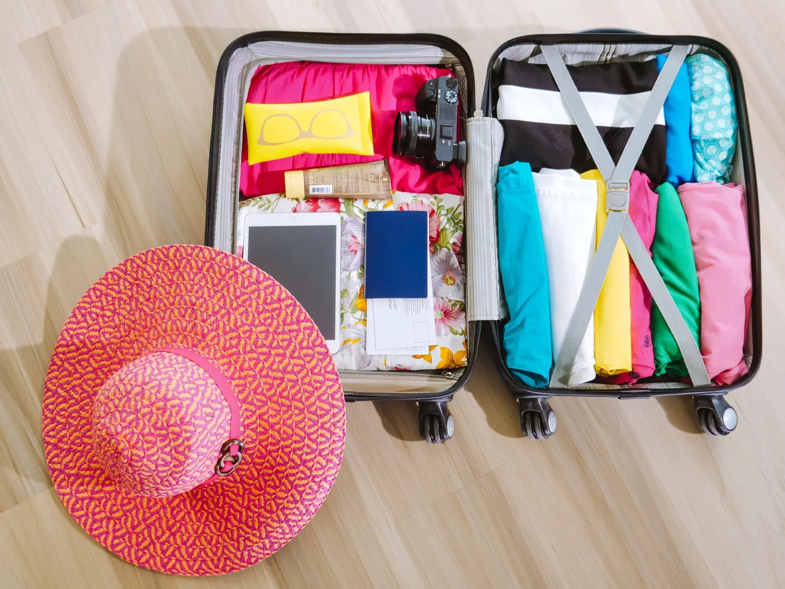 Cruise packing list essentials laid flat on a bed with a suitcase