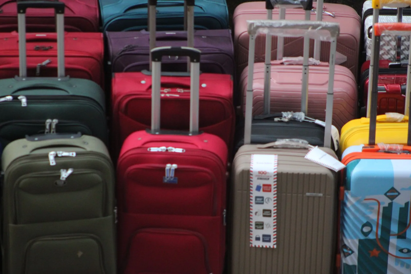 Carry on luggage vs checked luggage: a traveler chooses between a compact roller and a large suitcase at the airport