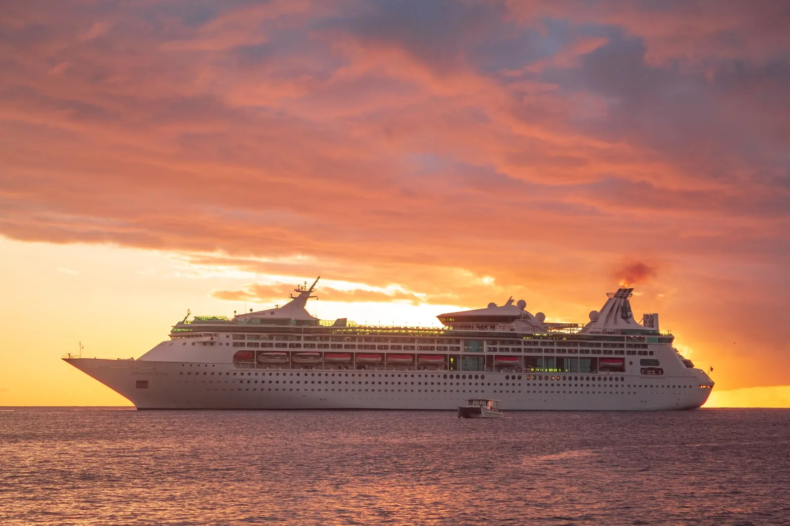 Cruise ships docked in a Caribbean port on a sunny day, with turquoise water stretching to the horizon