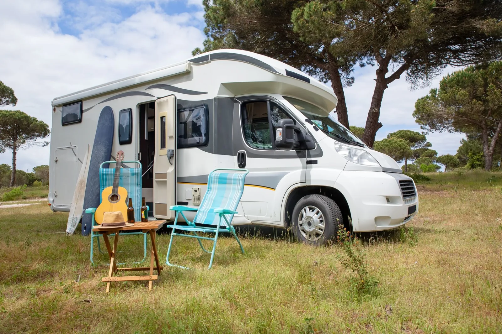 RV parked at a campsite surrounded by pine trees at dusk