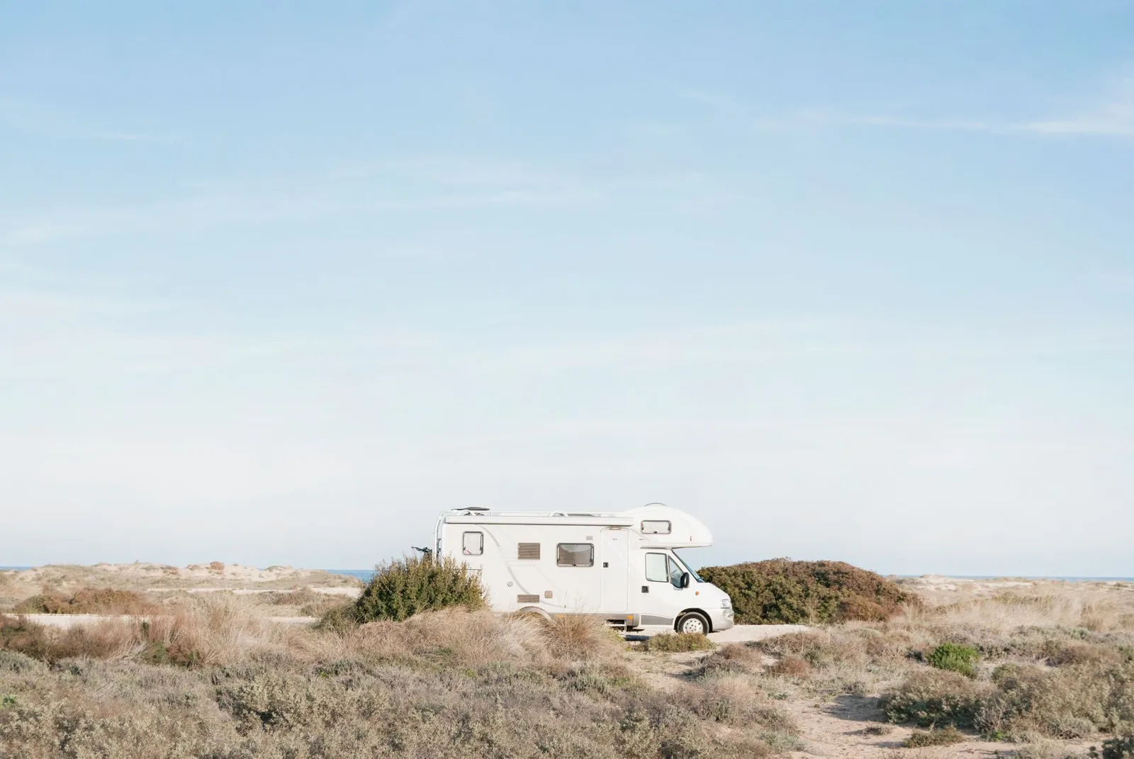 Class C motorhome parked at a wooded campground